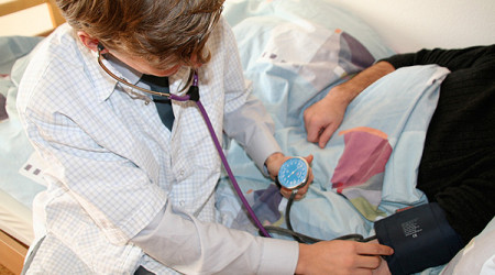 Hausarzt bei der Blutdruckmessung